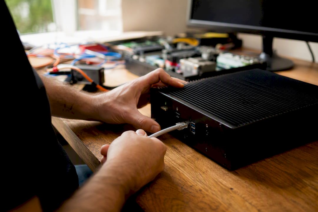 Trader hands plugging cable into trade copier device